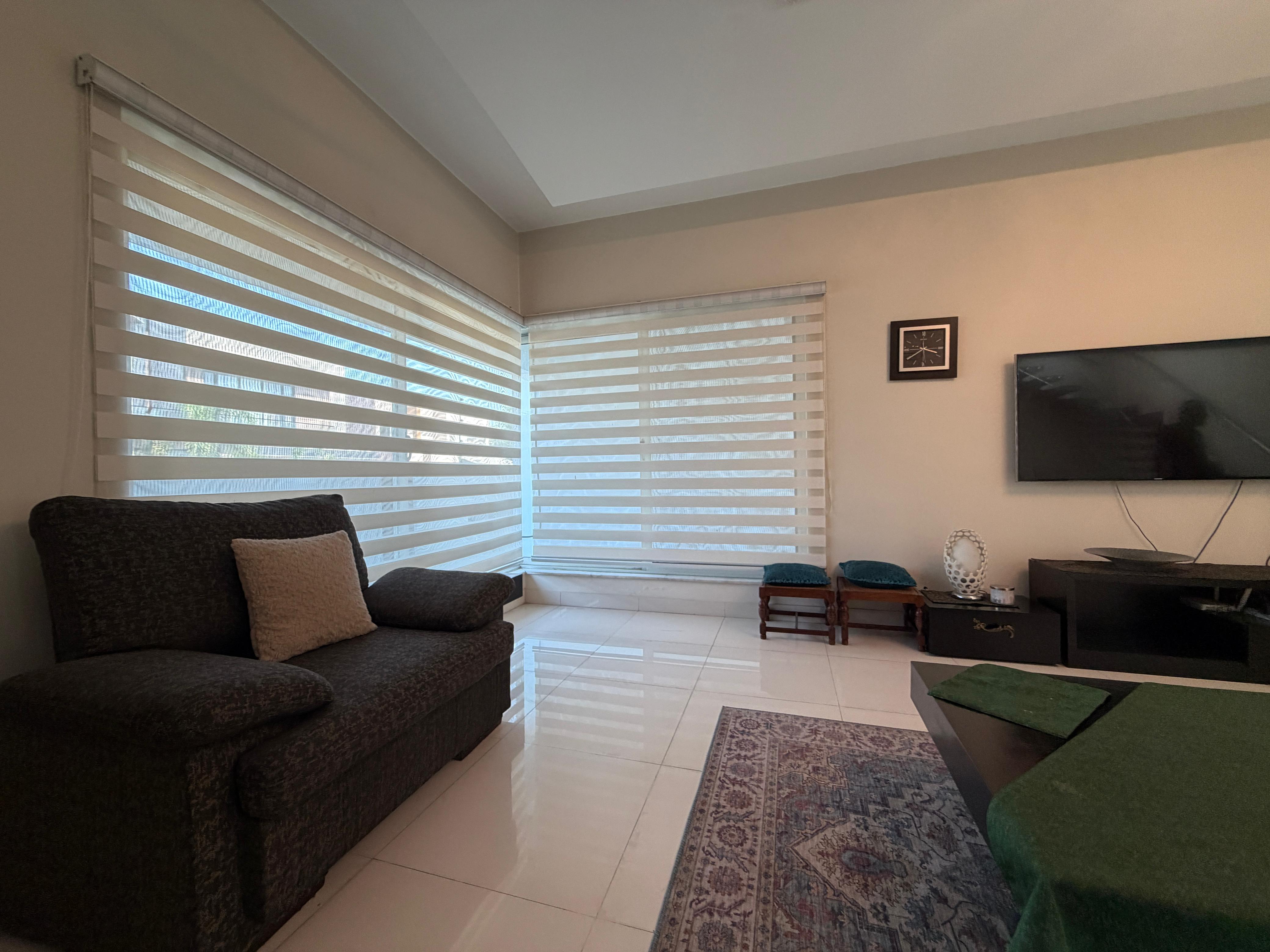 Luxury sunlit living room with custom window blinds in Pakistan